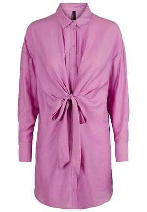 Pitkähihainen vaaleanpunainen kauluksellinen nappipaita, jossa edessä solmittava rusetti ja satiinimainen kangas.