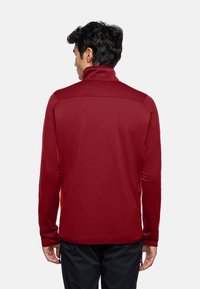 Roter Pullover mit langen Ärmeln und hohem Kragen, mit kontrastierenden orangen Seiten und strukturiertem Stoff. Entworfen für eine lockere Passform.