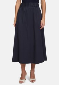 Jupe en coton bleu marine avec une taille élastique, design longue longueur et détails de couture subtils à l'ourlet. Texture lisse, style simple.