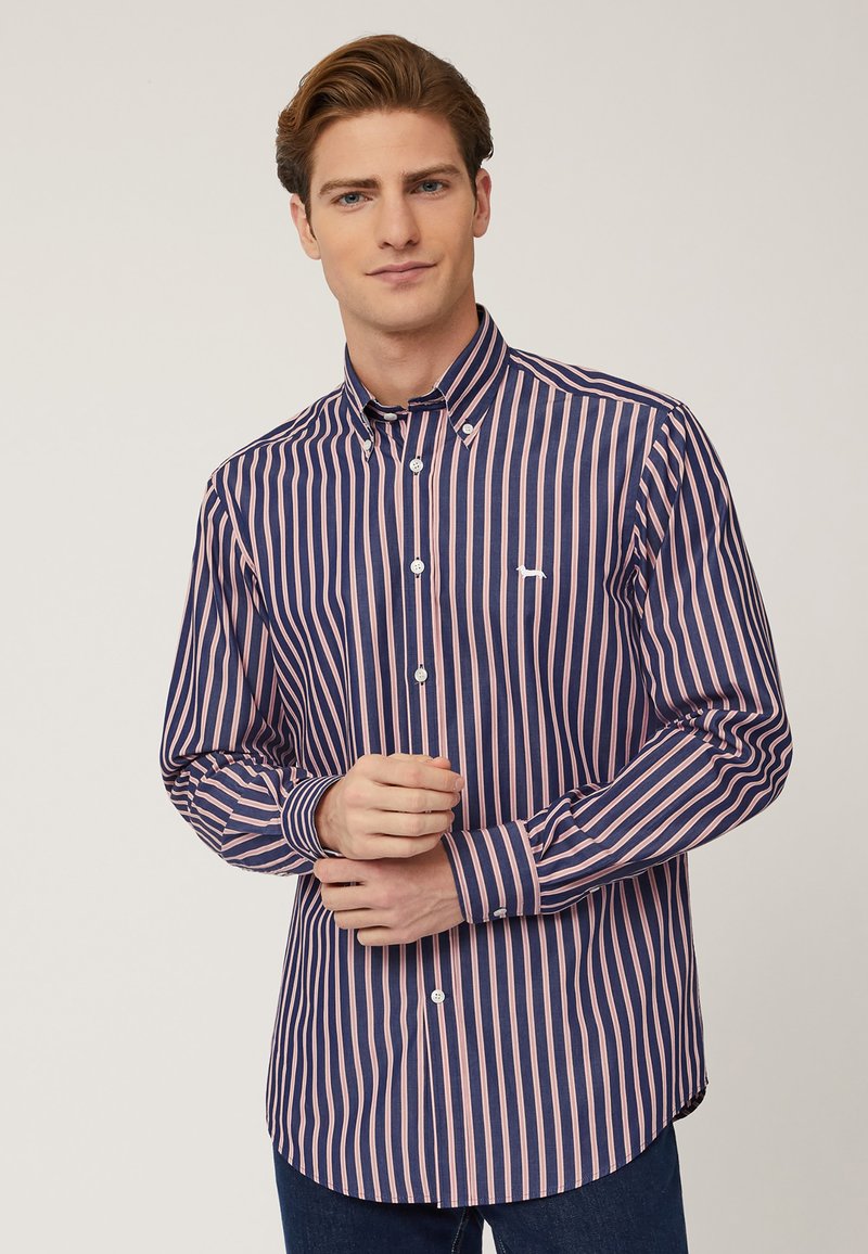 Camicia button-up con strisce verticali navy e rosa, maniche lunghe, colletto a punta e un piccolo logo sul petto. Materiale in cotone.
