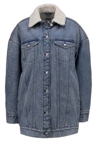 Džínová bunda ve světlé modré barvě s bílým límcem z beránkového materiálu, zapínáním na knoflíky, dvěma náprsními kapsami a volnějším střihem. Texturovaná látka.