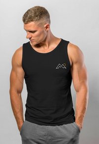 Schwarzes ärmelloses Tanktop mit einem weißen und orangefarbenen Berg-Graphic auf der linken Brust. Weicher Stoff und lockere Passform.