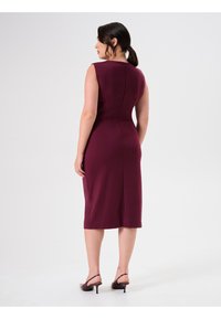 Mauve mouwloze jurk met een getailleerd ontwerp, knielange zoom, rits aan de achterkant en subtiele naaddetails. Eenvoudige, gladde textuur.