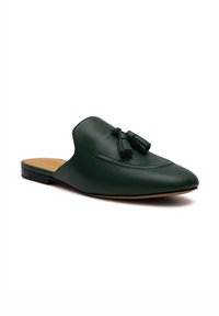 Scarpa slip-on verde in pelle con punta affusolata, dotata di due nappe decorative sul davanti e una suola nera piatta.