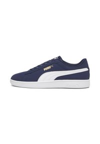 Mørkeblå sneakers med hvide detaljer, der har en glat tekstiloverdel, rund tå, flad hvid sål og detaljer med guld-logo på siden.