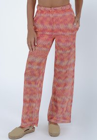 Pantaloni ampi e patterned con un design a zigzag in tonalità di rosa e arancione. Realizzati in tessuto leggero con vita elastica.