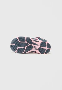 Sneaker sula med design i rosa och marinblått. Har texturerad gummi för grepp och flexibilitet, med tydliga mönster och rundade detaljer.
