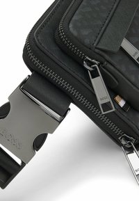 Black textured bag with two silver zipper pulls and a metal clasp engraved with the brand name "BOSS."