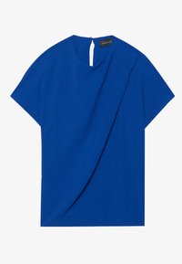 Top azzurro a maniche corte con finitura testurizzata, caratterizzato da un davanti drappeggiato e un piccolo apertura a forma di chiave sul retro. Etichetta visibile all'collo.