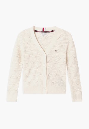 Cardigan tricoté couleur crème avec col en V, fermeture par boutons, poignets et bord-côte, et petit logo brodé sur la poitrine gauche.
