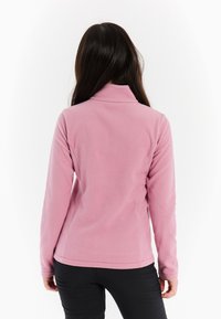 Helle rosa Fleecejacke mit hohem Kragen und langen Ärmeln, ausgestattet mit einer glatten Textur und tailliertem Design.