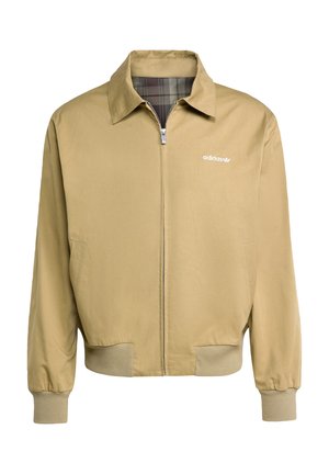 Chaqueta cremallera color tostado con cuello puntiagudo, puños elásticos y forro de cuadros. Presenta un logo de adidas en blanco en el lado izquierdo del pecho.