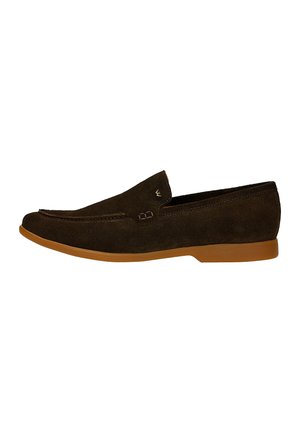 Bruine suède mocassinschoen met een ronde neus, elastische accenten en een rubberen zool, die een minimalistisch ontwerp en contrasterende stiksels heeft.