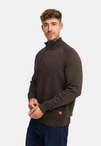 Brun strikket sweater med ribbet krave og tre knapper, med teksturerede ærmer og et lille logo mærke i kanten.