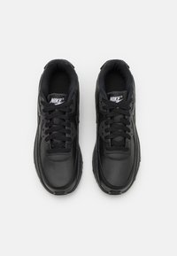 Schwarze Leder-Sportschuhe mit einem strukturierten Obermaterial, runder Zehenpartie und flachen Schnürsenkeln. Verfügt über einen gepolsterten Kragen und das Nike-Logo auf der Zunge.