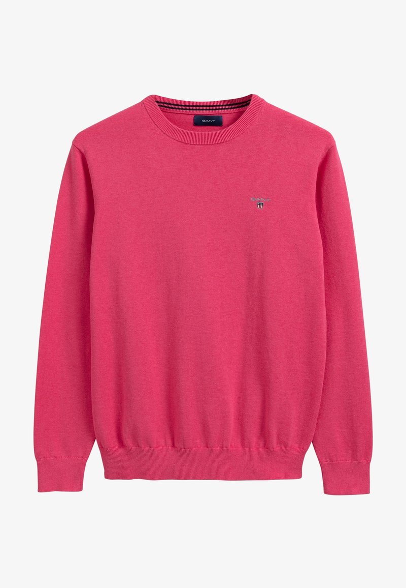 Pull rose à col rond avec manches longues et poignets, ourlet et encolure côtelés, arborant un petit logo brodé sur la poitrine.
