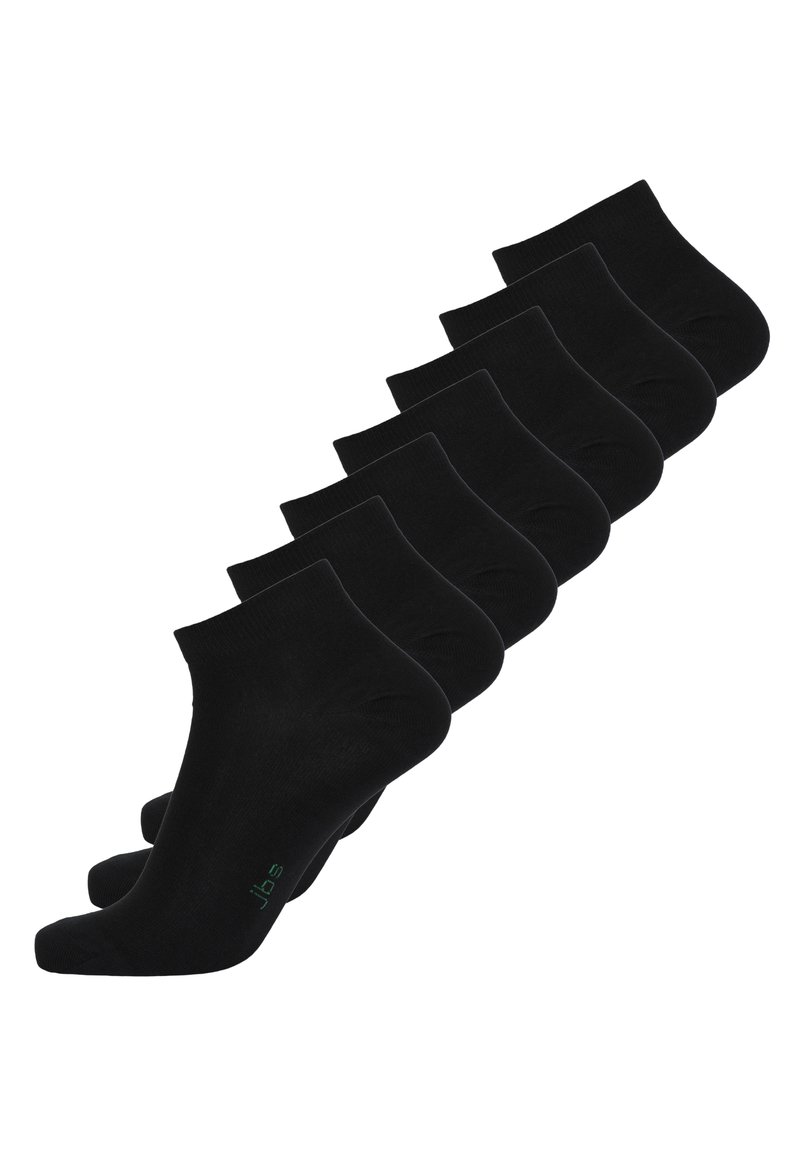Schwarze Knöchelsocken in einer Reihe angeordnet, aus einem glatten, dehnbaren Material mit einem gerippten Bündchen. Grüner Logoakzent auf einer Socke.