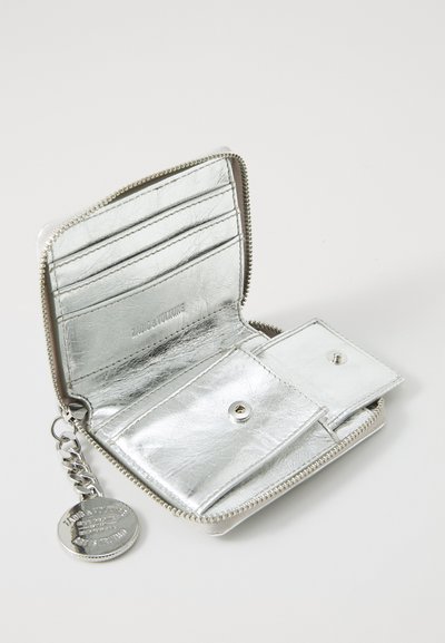 Silver metallic wallet made of shiny textured material, featuring card slots, a snap closure, and a chain with a round metal tag.