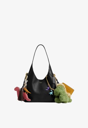 Sac à bandoulière noir décoré de porte-clés dinosaures colorés, d'un dinosaure en peluche vert, d'une chaîne dorée et d'une étiquette en cuir Coach.