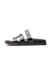 Schwarze Leder-Sandalen mit zwei breiten Riemen, einer strukturierten Oberseite und einer flachen Gummisohle. Mit einem Logo auf dem Riemen.
