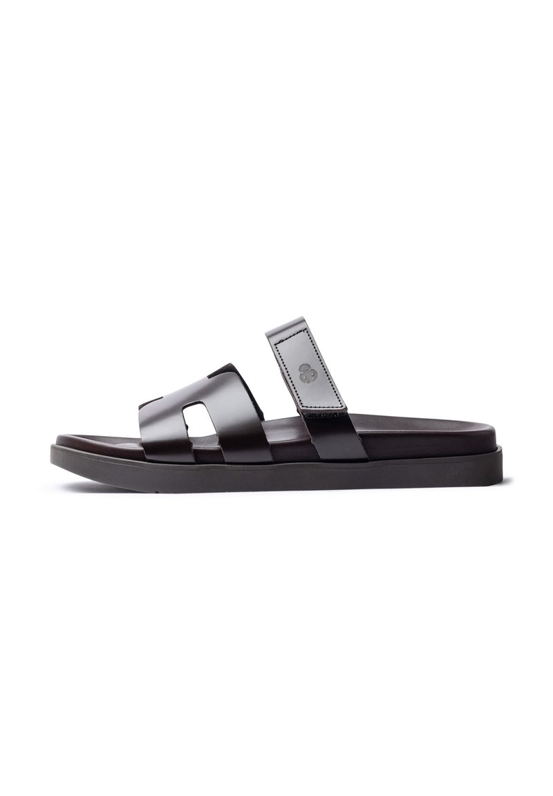 Schwarze Leder-Sandalen mit zwei breiten Riemen, einer strukturierten Oberseite und einer flachen Gummisohle. Mit einem Logo auf dem Riemen.