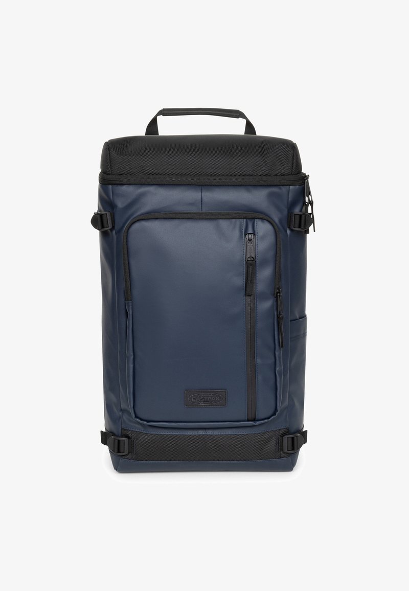 Navy modrý batoh s černým vrškem, vyrobený z odolné látky. Má přední kapsu na zip, boční kapsu a nastavitelné popruhy.