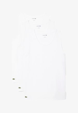 Kolme valkoista puuvillapaitaa, joissa on ribbireunus kauluksessa ja pieni vihreä Lacoste-logo kunkin paidan vasemmassa alareunassa.