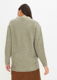 Pullover overdimensionato di un verde chiaro con una superficie tessurizzata e morbida, maniche lunghe, scollo rotondo e vestibilità rilassata.