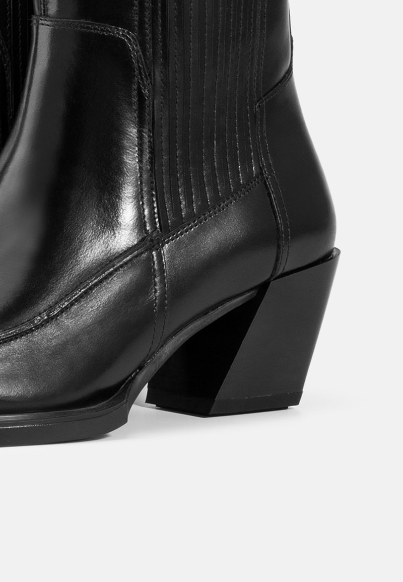 Black leather ankle boot featuring a block heel, ribbed detailing on the sides, and a smooth, shiny finish.