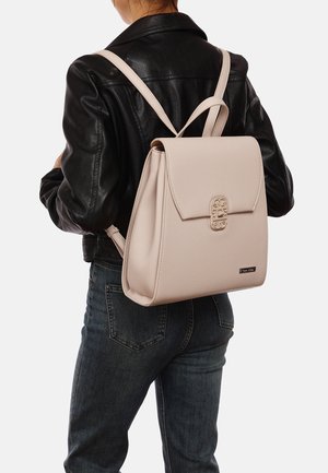 Sac à dos en cuir rose clair au design structuré, avec un détail de fermeture à l'avant, deux bretelles et une forme rectangulaire.