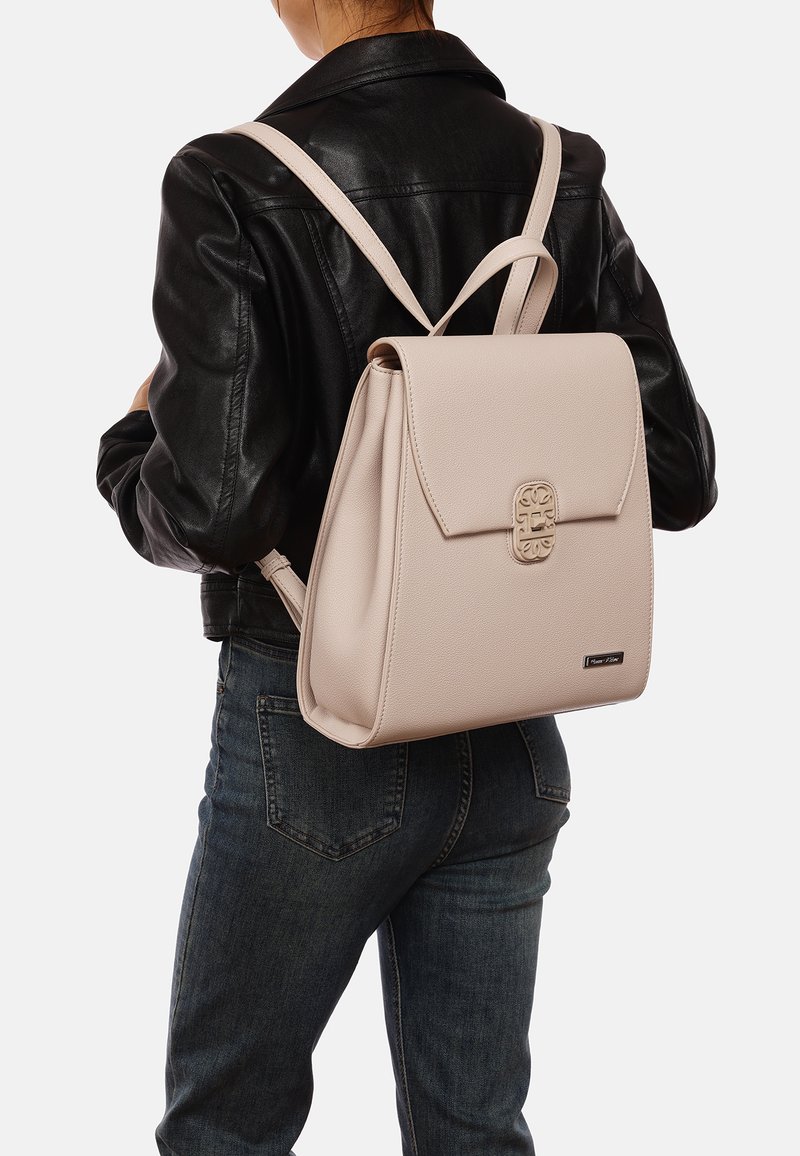 Sac à dos en cuir rose clair au design structuré, avec un détail de fermeture à l'avant, deux bretelles et une forme rectangulaire.