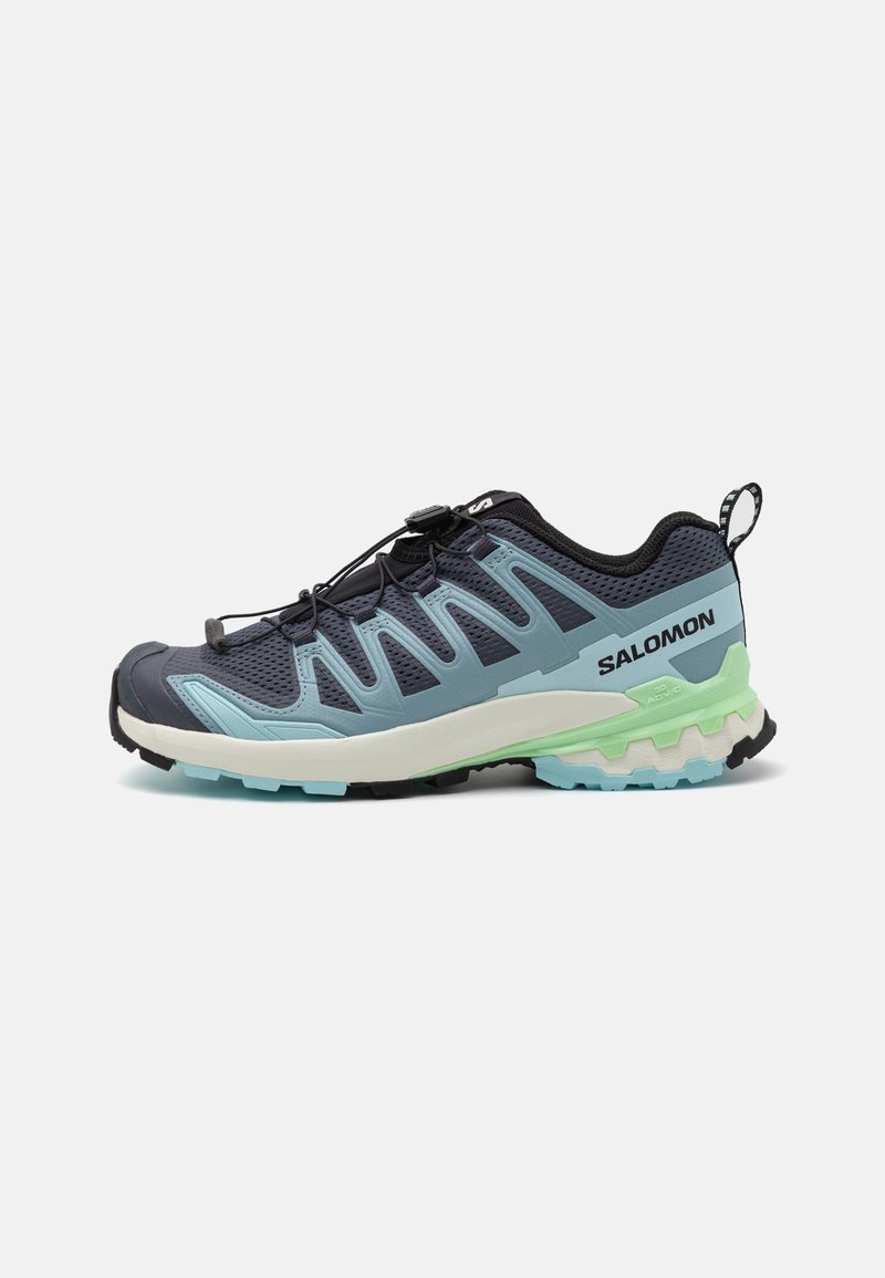 Trail running shoe featuring a navy and light blue mesh upper, textured outsole, quick-lace system, and green accents on the midsole.