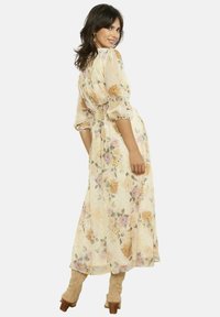 Lilleline maksikleit helebeežis toonis, pallvarrukate, vöökoha alt lõigatud ja voolava seelikuga. Kaunistatud roosade, oranžide ja roheliste lillemustritega.