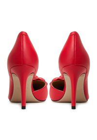 Pantofi cu toc înalt din piele roșie, cu vârful ascuțit și tocuri subțiri de tip stiletto. Textură netedă cu un design decupat la călcâi.