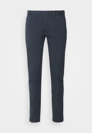 Chinos azul-marinho feitos de algodão leve, apresentando um corte reto, fecho de botão e bolsos frontais. Textura suave com detalhes mínimos.