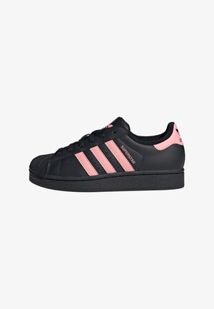 Sneakers neri in pelle con tre strisce rosa, suola in gomma e dettagli perforati. Punta arrotondata con un cappuccio testurizzato.
