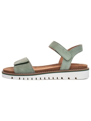 Sandale en daim vert clair avec des brides réglables sur les orteils et la cheville, une semelle intérieure marron rembourrée et une semelle extérieure en caoutchouc blanche à rainures.