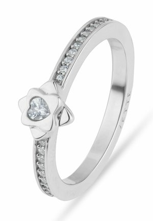 Zilveren ring met een centraal hartvormige diamant in een bloem gezet, met kleine diamanten ingebed langs de band.