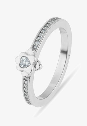 Sølvring med en hjerteformet central diamant sat i en blomst, med små diamanter indlejret langs båndet.