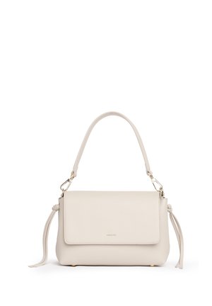 Borsa a mano in pelle color crema con chiusura a patta, manico superiore, minuteria color oro e nappine decorative sui lati, su sfondo bianco.