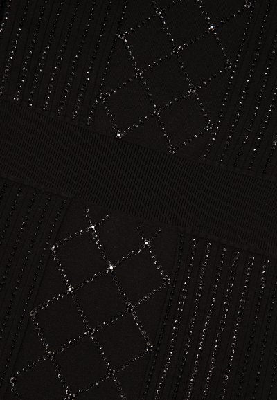 Zwarte jurk met gestructureerde patronen, met verticale lijnen en diamantvormen versierd met zwarte pailletten. Voorzien van een geribbelde tailleband.