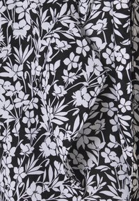Černá látka s bílým květinovým vzorem, který zahrnuje malé květy a listy. Textura vypadá jemně a hladce s mírným leskem.