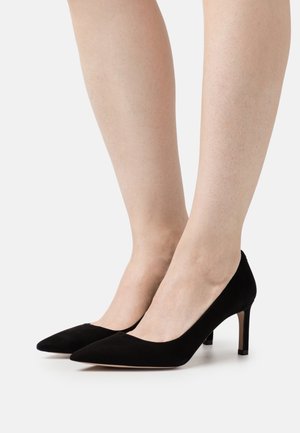 Escarpins en daim noir à talons hauts, avec un bout pointu, un design minimaliste et un talon élancé de 3 pouces. Texture lisse et sans éléments métalliques apparents.