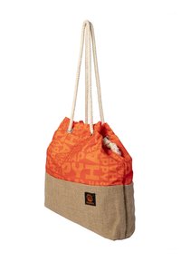 Orange and beige tote bag with rope handles, "HAPPY" text pattern on orange fabric, and a small square patch near the bottom.