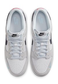 Nike-sneakers med en vit läderövre del, ljusgrå mockadetaljer, blå accenter och en klassisk snörningsdesign.