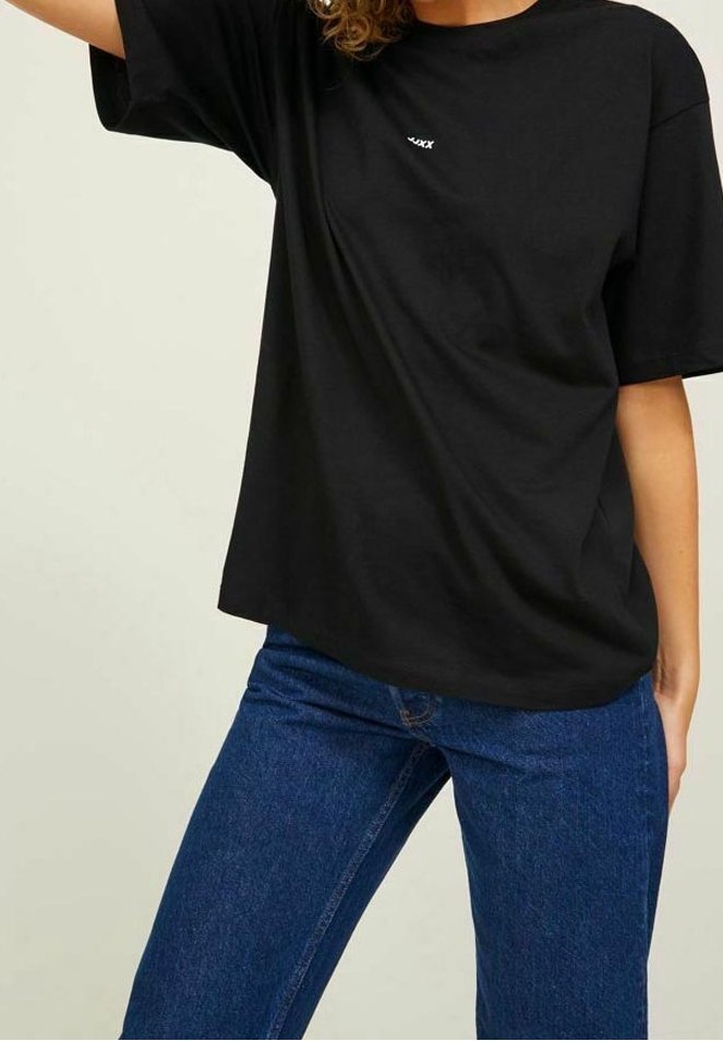 Black cotton t-shirt with short sleeves and a round neckline. Features a small white logo on the front. Paired with blue denim jeans.