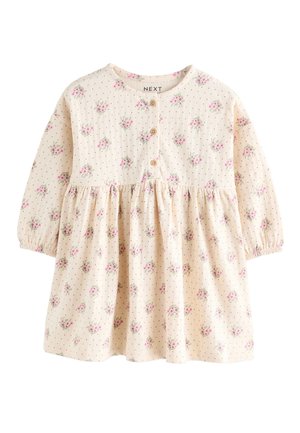 Béžové detské šaty s dlhým rukávom s ružovým kvetinovým vzorom, malými čiernymi bodkami, tromi drevenými gombíkmi vpredu a elastickými manžetami.