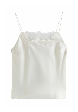 Balta satīna kamizole ar mežģīņu apdari gar izgriezumu, regulējamiem plāniem siksniņām un gludu tekstūru. Vienkāršs dizains, bez rakstiem.