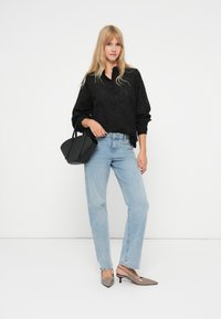 Svart øyeblikk bluse med krage, lyseblå rett ben jeans og grå hæl mules. Tilbehør: liten svart håndveske.