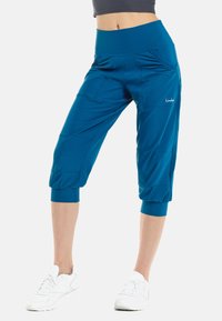 Pantalones capri turquesas hechos de una tela elástica, con una cinturilla ancha, bolsillos laterales y dobladillos ajustados en los tobillos.